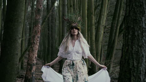 beautiful natural fairy with white veil walking in forest, front dolly shot