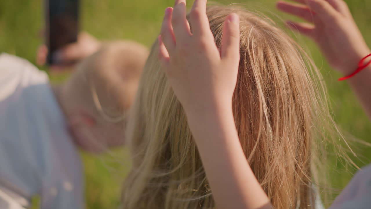 A tender moment where a child's hand is seen touching his mother's hair, while another child appears blurred in the background. The focus is on the intimate connection between mother and child