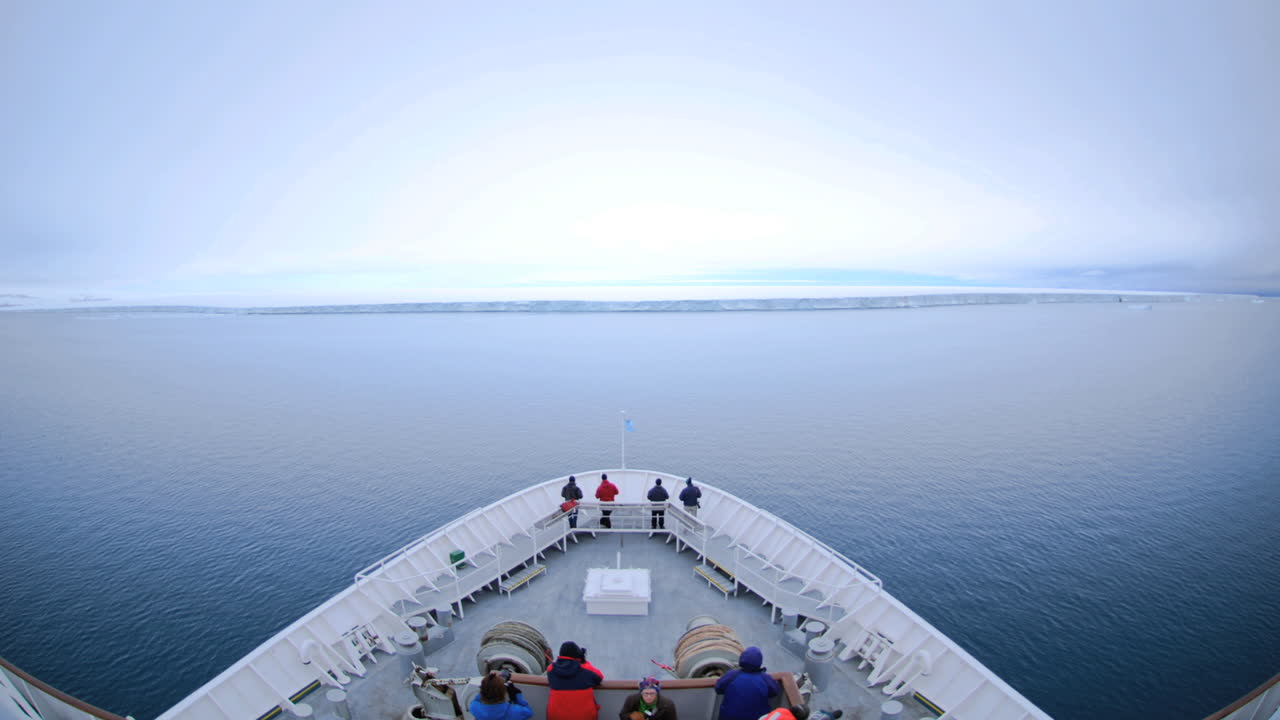 punto de vista de un enorme barco acercándose a unos pies de un enorme iceberg cerca de noruega nordaustland