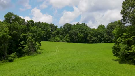 drone flying over farm land showing the fields and woods in the area