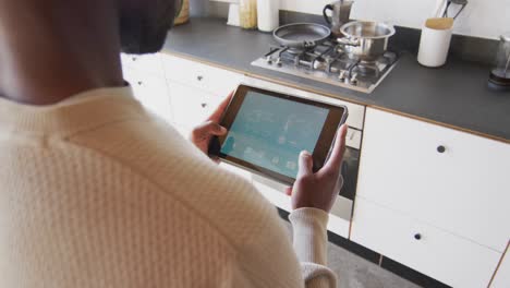 Midsection-of-african-american-man-using-tablet-with-weather-forecast