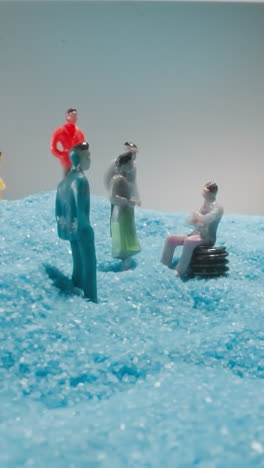 figures of men and women tourists standing on soft blue sand shimmering at bright light. man sits on bench enjoying conversation with family and friends macro