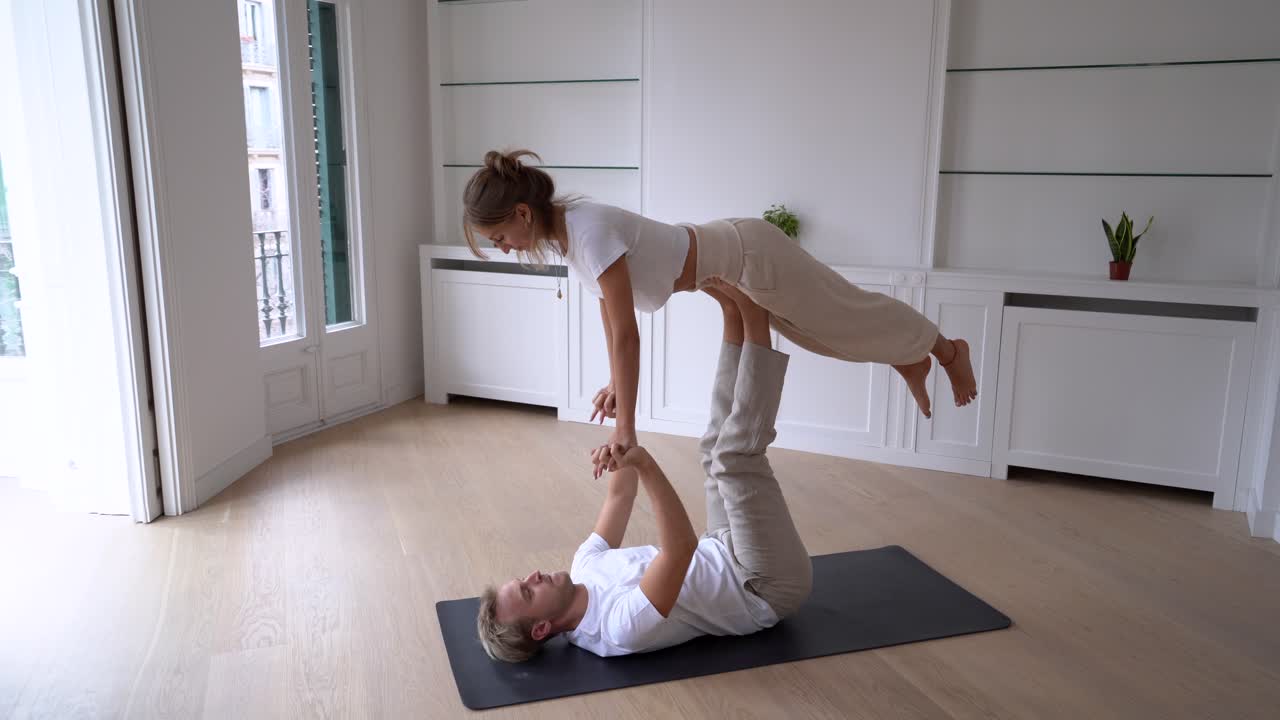pareja practicando acro yoga juntos en casa