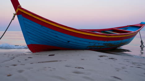 colorful wooden fishing boat on the beach at sunset