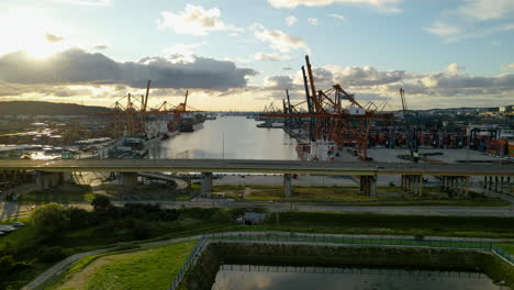 aerial panorama of gdynia port cargo container terminal yard and shipping cranes at baltic sea on picturesque sunset