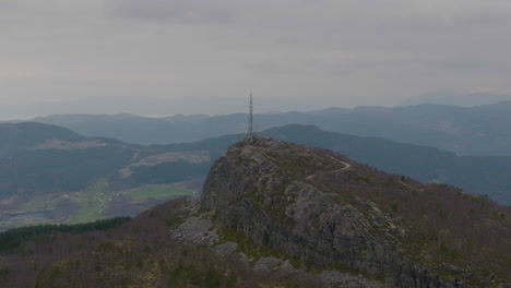 Drohnen-Rückzugsaufnahme-Einer-Telefonmaststruktur,-Die-Auf-Der-Bergspitze-Positioniert-Ist