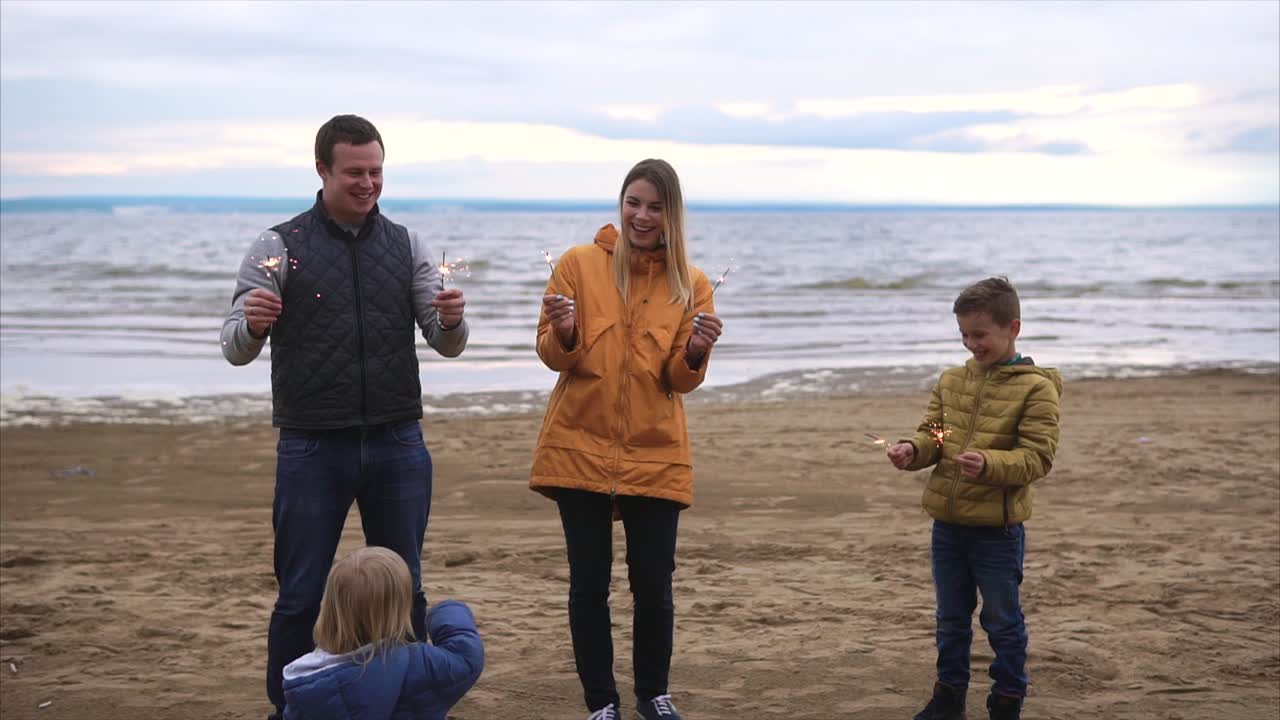 Happy Family Celebrating on the Beach with Sparkler