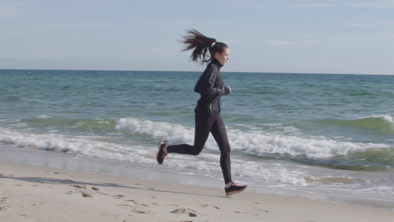 Young woman exercising jogging outdoor running with ocean horizon on the beach