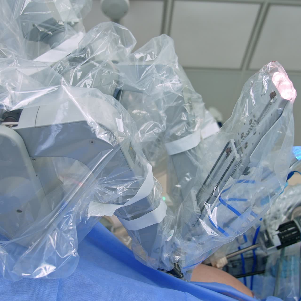 Going round the robotic arms of Da Vinci robot. Futuristic equipment operating the patient in modern surgery room