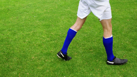 jugador de fútbol pateando una pelota en el campo