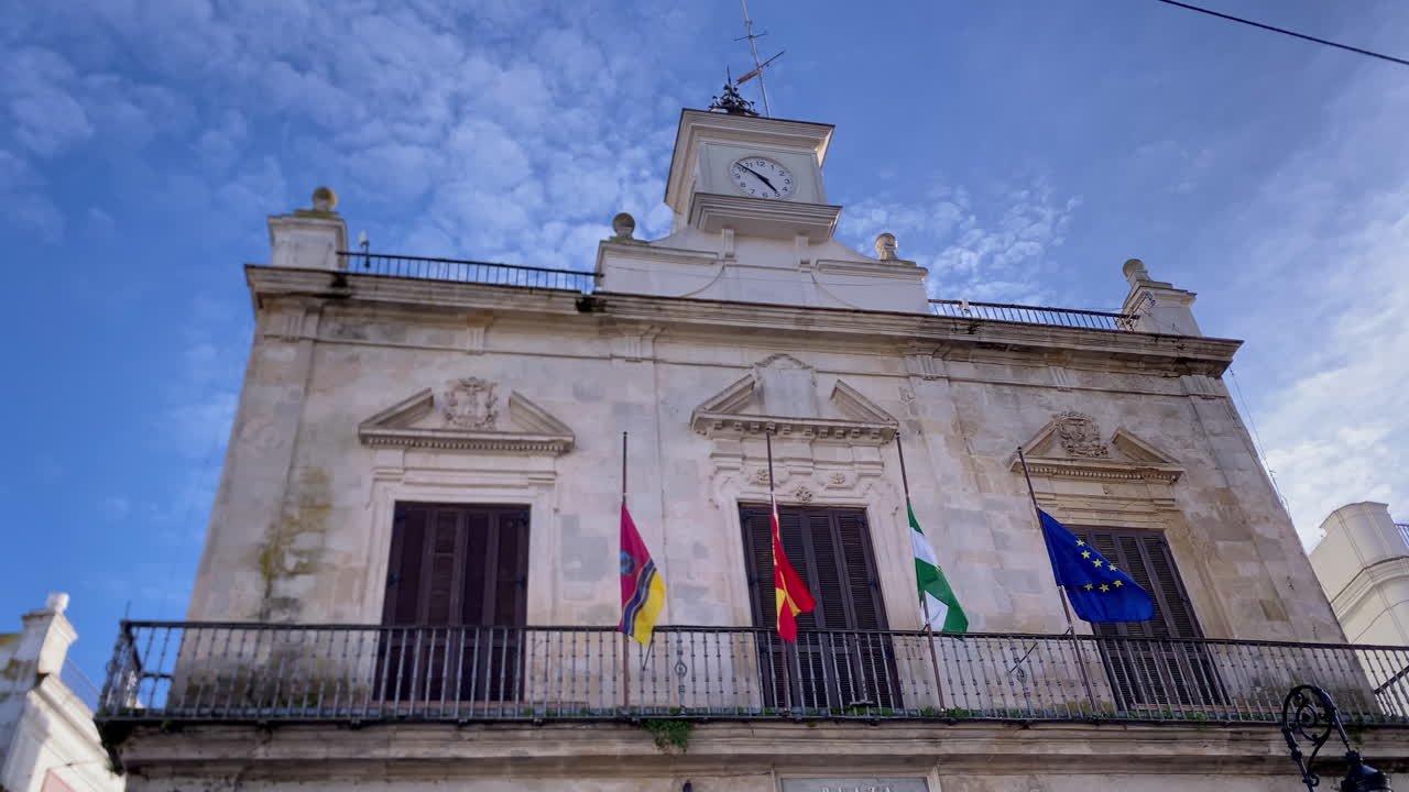 Edificio storico del municipio a Sanlúcar de Barrameda, Andalusia, che espone la bandiera spagnola, andalusa e dell'Unione Europea.