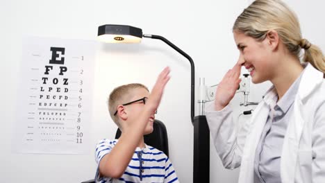 optometrista dándole cinco a un joven paciente