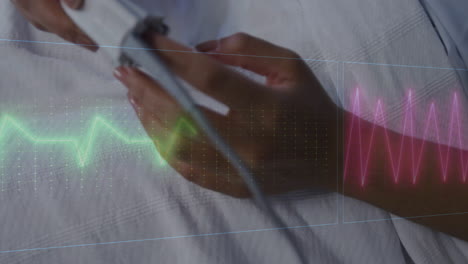 animation of cardiographs over senior biracial woman lying in hospital bed
