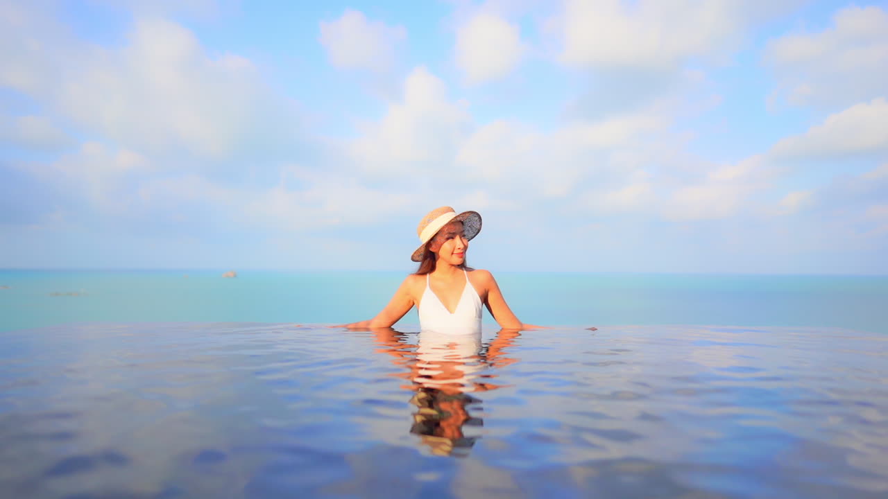 열대 카리브해 지역의 인피니티 수영장에 있는 고급스러운 이국적인 여성