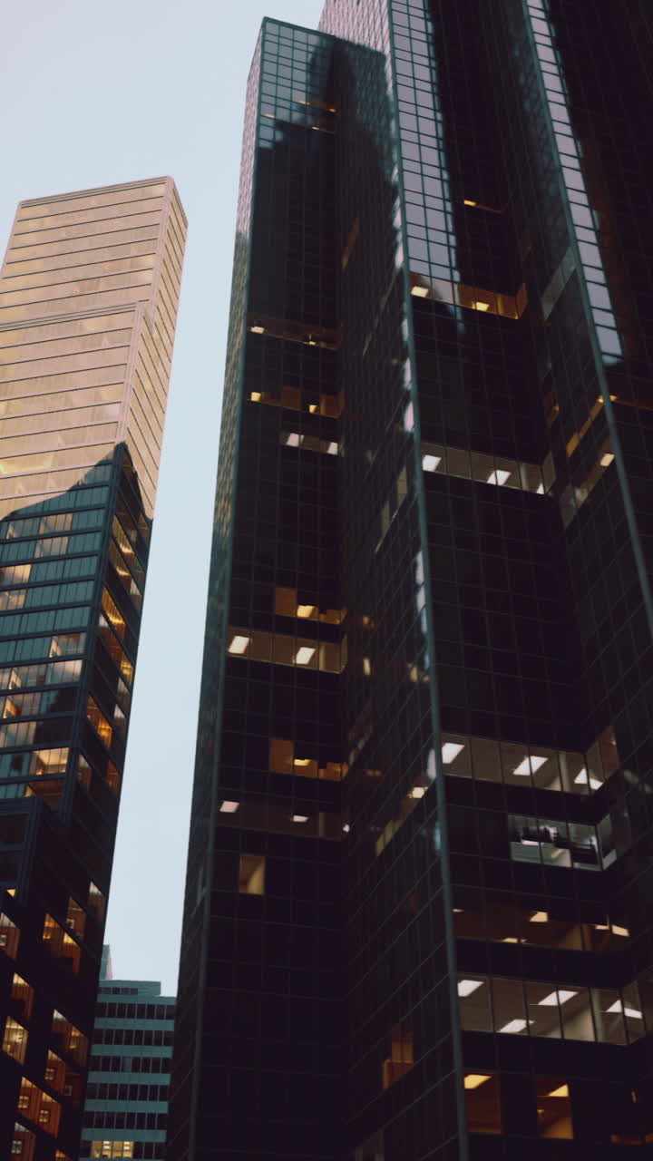 Modern skyscrapers illuminated at dusk in an urban setting