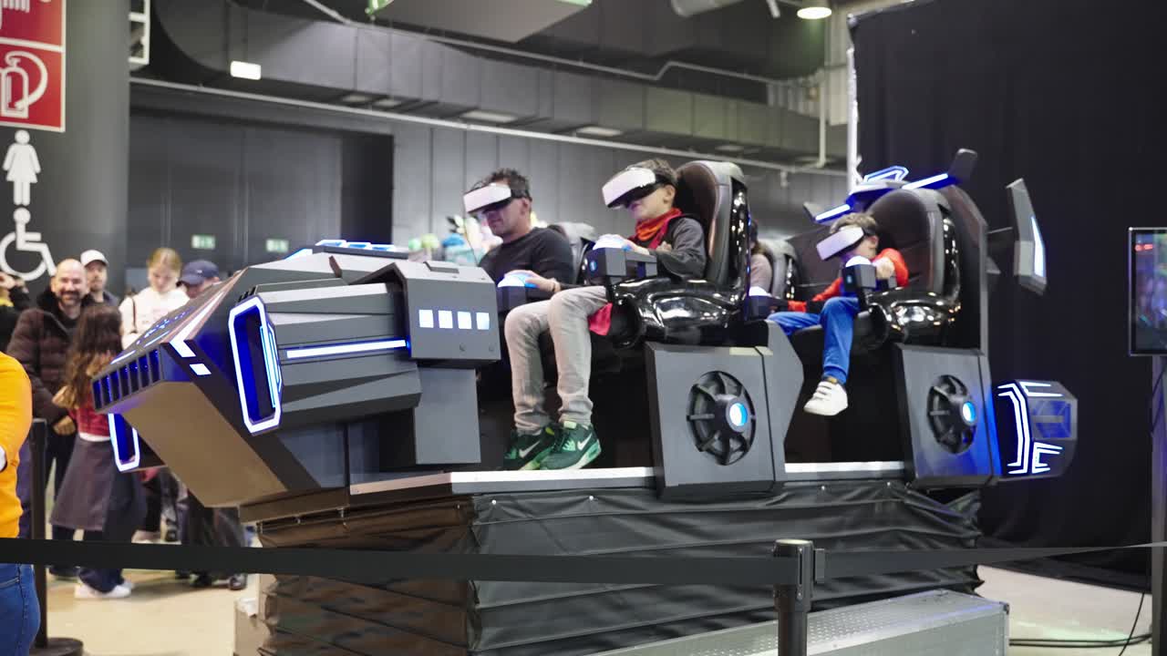 Family riding on a cool virtual Rollercoaster machine with VR goggles on a convention at LGX event in Luxembourg. Father having fun with his boys testing new games and entertainment technology