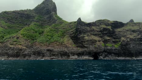 Tracking-shot-sailing-along-rugged-cliff-of-Na-Pali-Coast-of-Kauai,-Hawaii