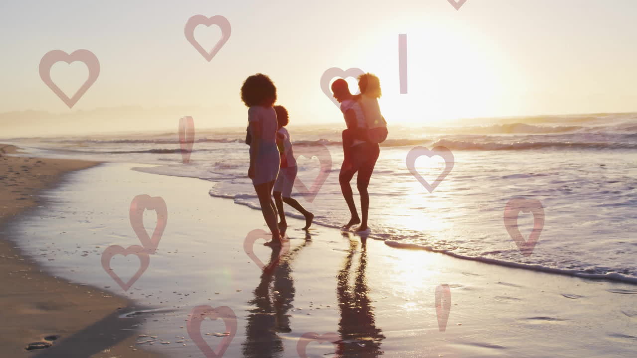 Family walking on beach at sunset with heart shapes animation overlay