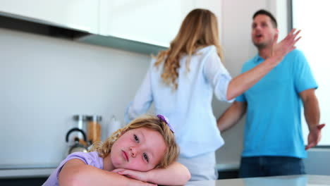 padres discutiendo detrás de su hija triste