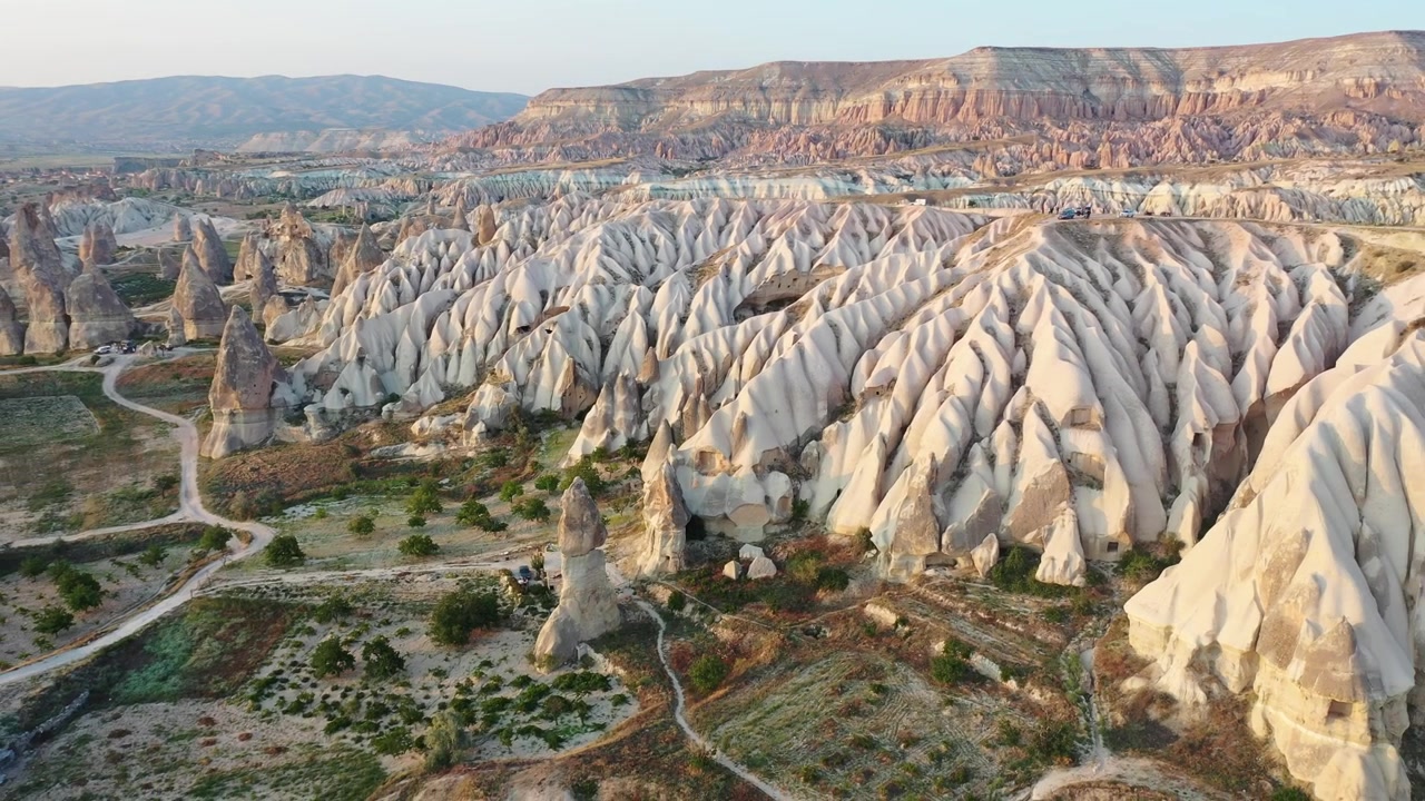 Vista panoramica aerea con drone delle iconiche formazioni rocciose a camino delle fate e delle ripide creste montuose di tufo erose nella Valle dell'Amore, Cappadocia, Nevsehir, Turchia, durante l'ora d'oro.