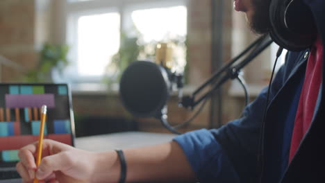 podcaster taking notes on paper in studio