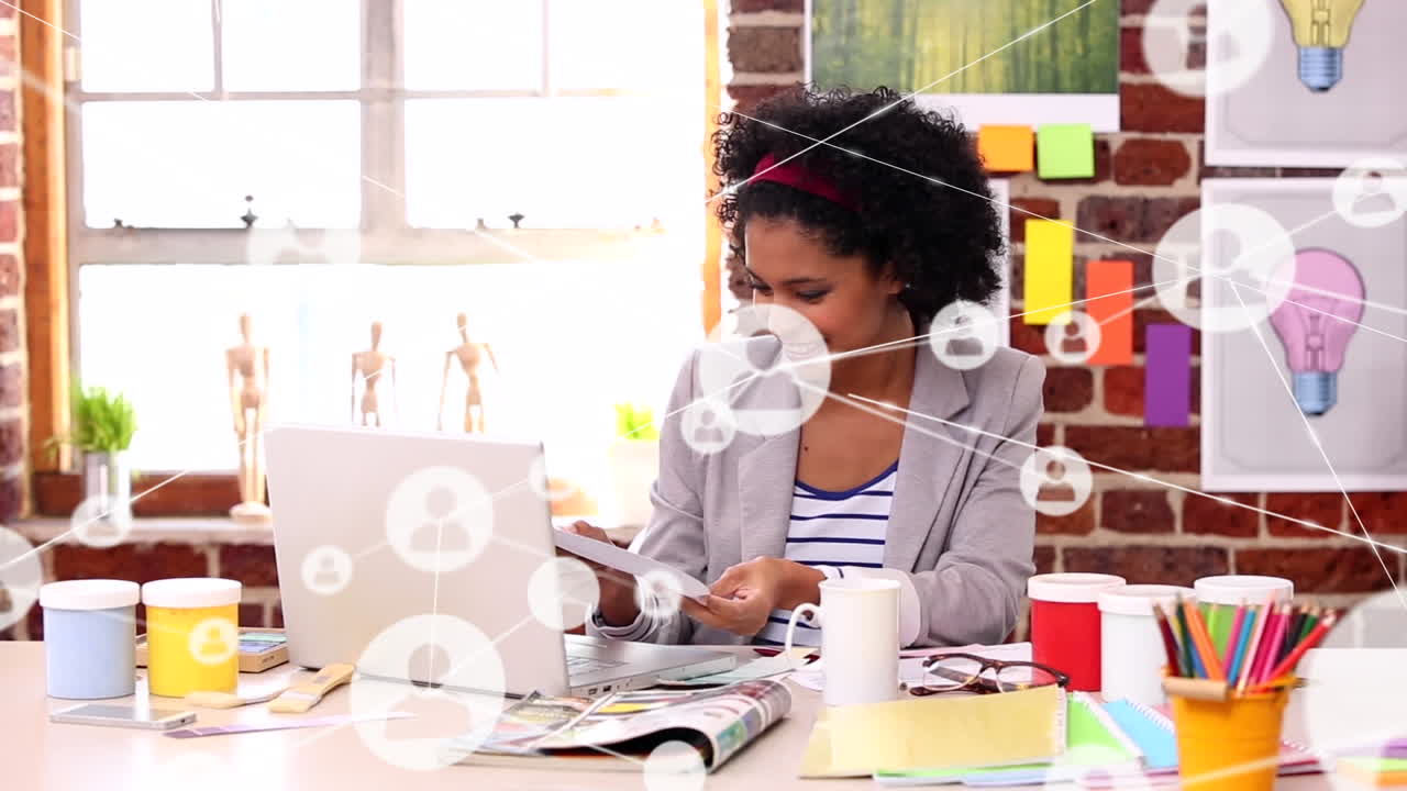 Animation of connected icons over biracial woman looking at drawing and showing it to camera