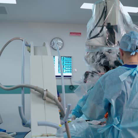 modern operating room. two doctors perform a surgery to a patient through the microscope in hospital. new equipment in medicine.