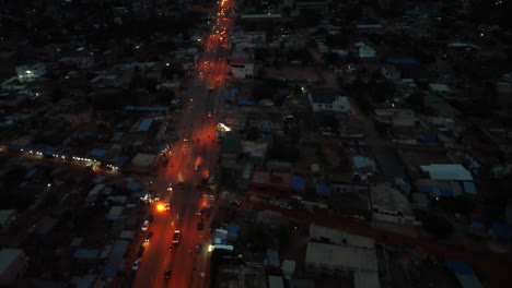 cinematic 4k aerial drone shot of road traffic at night with cars driving during rush hour in african city near the ocean - lomé, togo