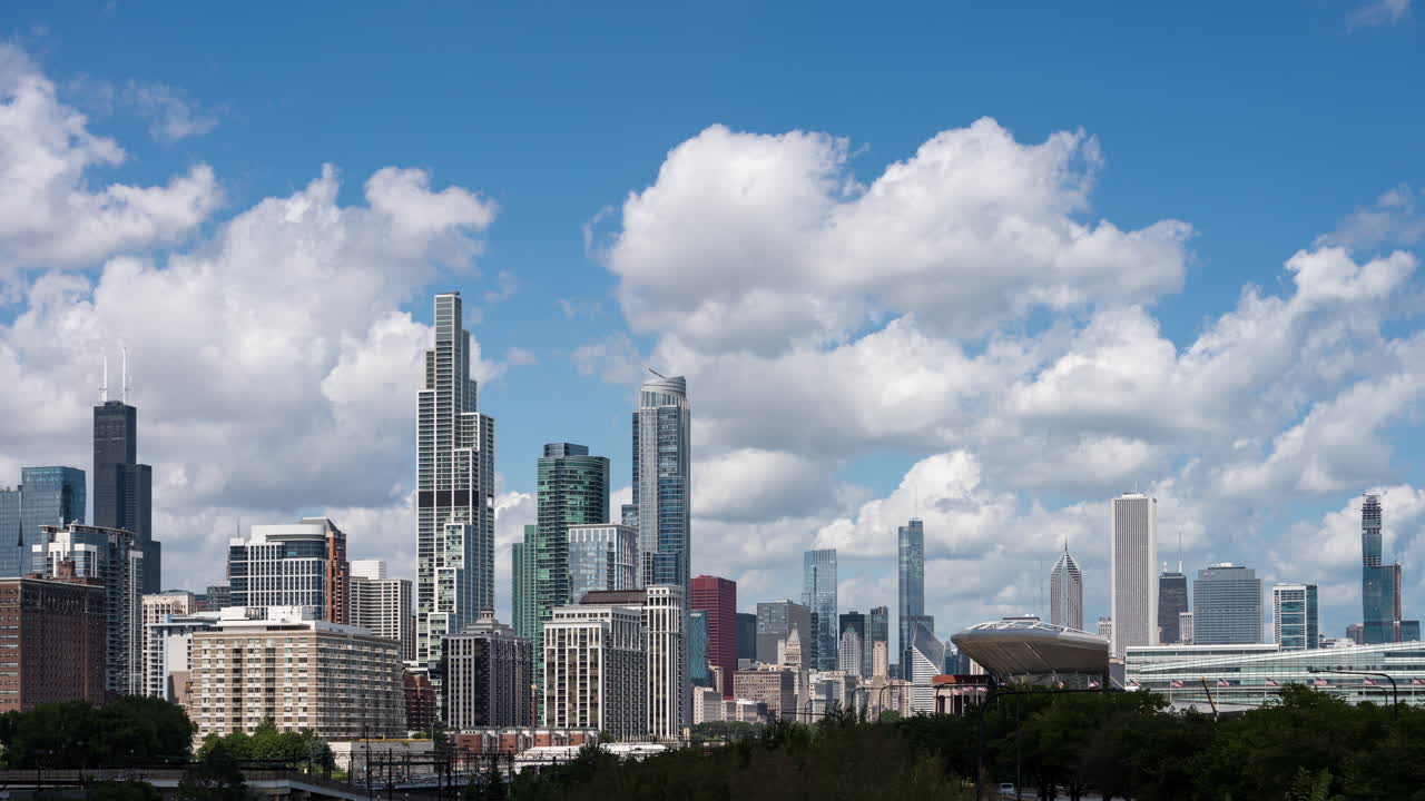 Time lapse establishing shot of large puffy clouds flowing through blue sky over the Chicago skyline as seen from the South Loop neighborhood