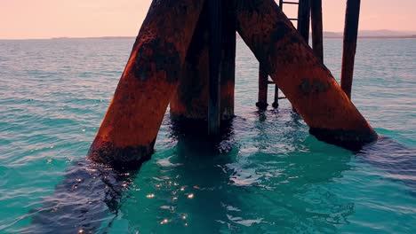 Circling-view-of-offshore-oil-platform-or-oil-rig-pylons-in-open-sea