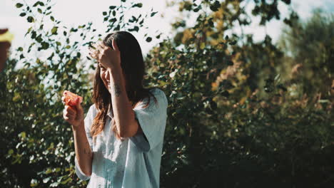 woman playing with a water gun in nature