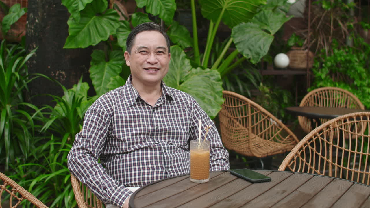 Portrait of Mature Man Drinking Juice at Outdoor Cafe