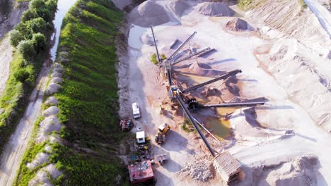 aerial orbit shot from a drone of quarry and heavy machinery in pomeranian district in poland