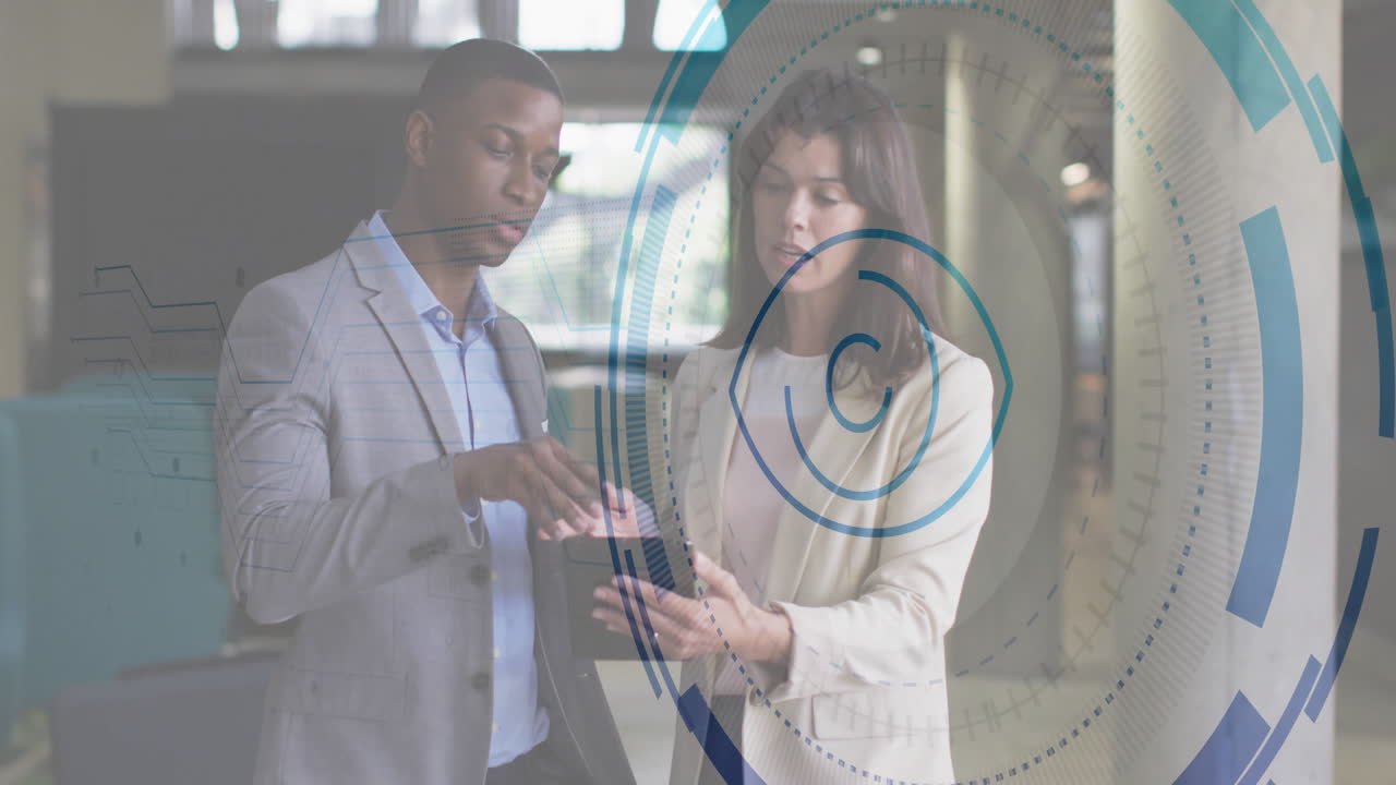 Colleagues reviewing tablet in corporate lobby, showcasing floating blue-gray technology overlays