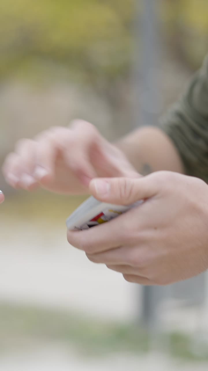 Man Performing a Card Trick Outdoors