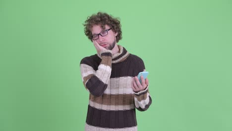 un joven guapo con barba y cabello rizado.