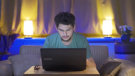 Man-focusing-on-computer-has-serious-expression.-At-home-at-night.