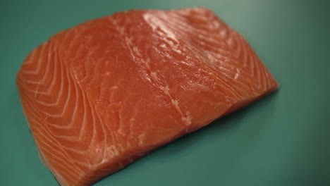 cerca de un filete de salmón crudo en una tabla para cortar