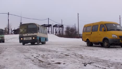 buses and van in a snowy industrial area