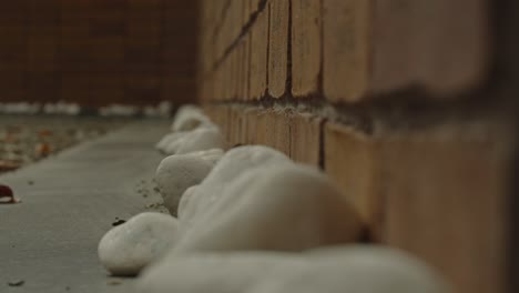 macro of small white pebbles at base of brick wall of the national holocaust names memorial in amsterdam, the netherlands