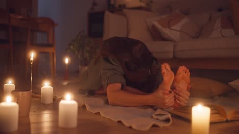 mujer estirándose en casa con velas
