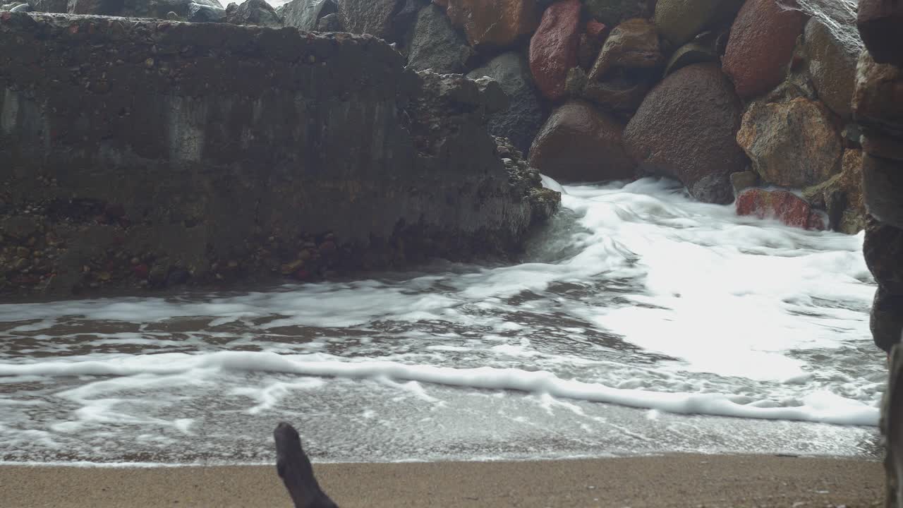 폭풍우 치는 날씨에 콘크리트 폐허를 때리는 파도