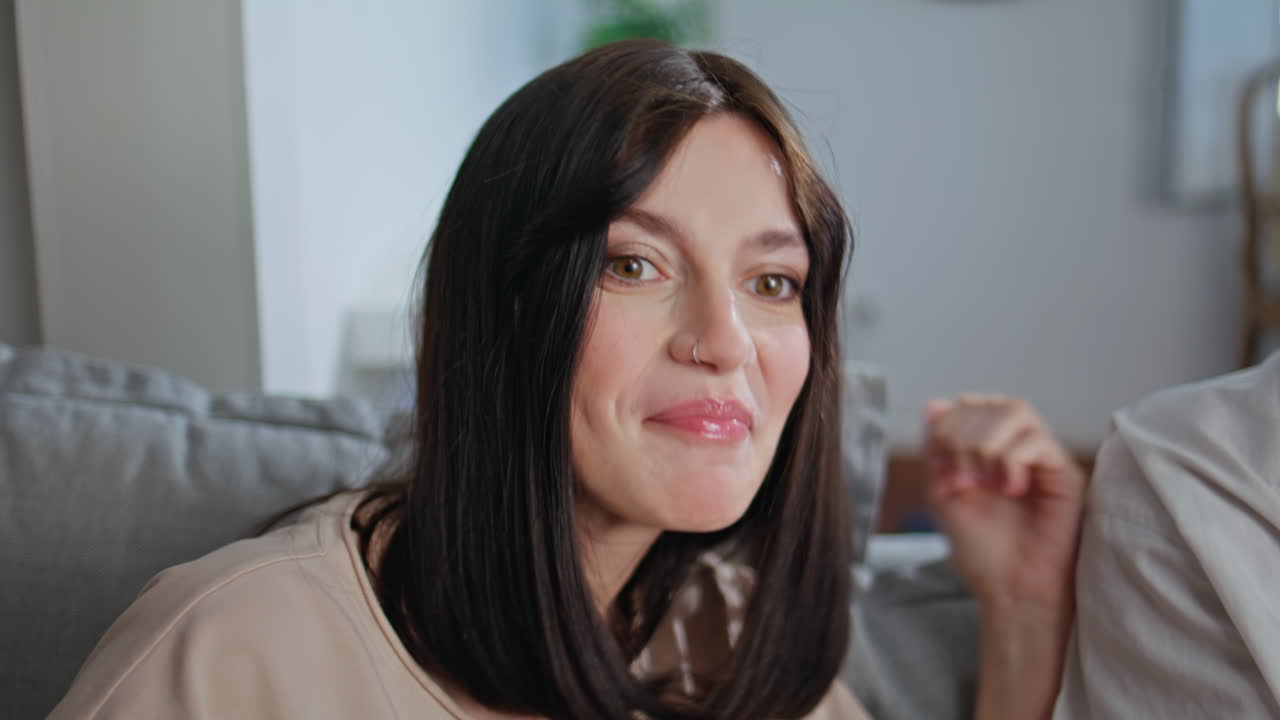 Excited woman supporting videogame player at sofa closeup. Girl watching game