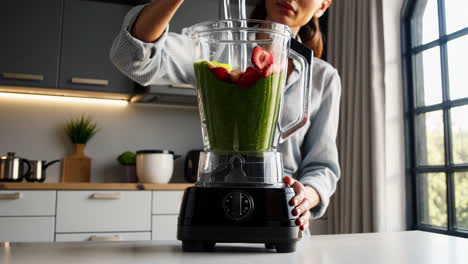 woman preparing a green smoothie