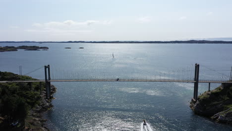 Boats-passing-under-bridge-into-ocean-on-a-sunny-day