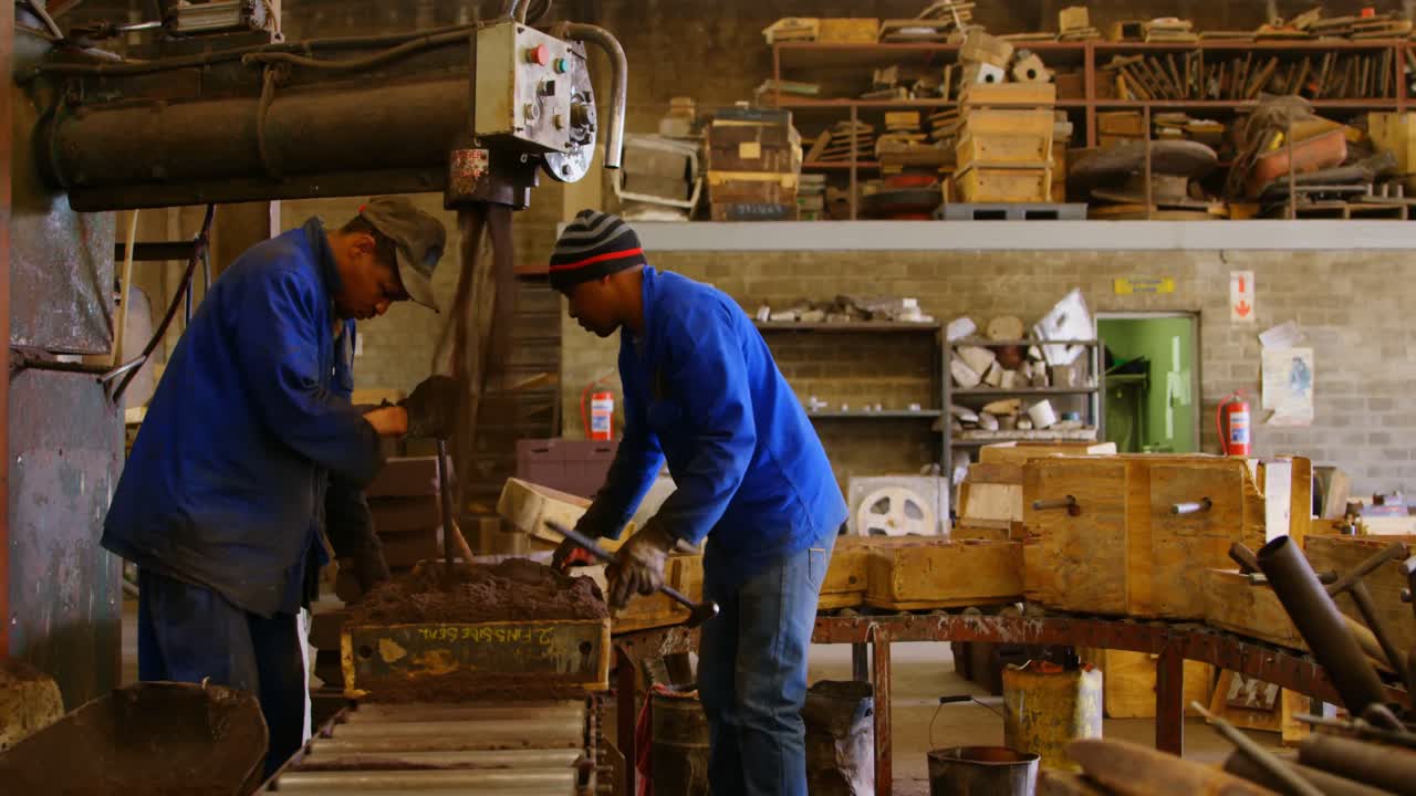 Workers putting soil in mold in foundry workshop 4k