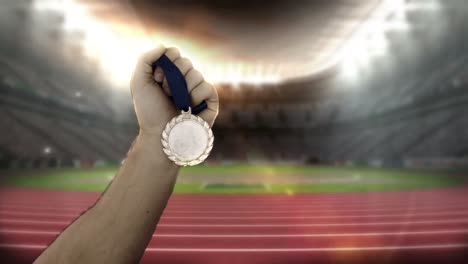 hand of athlete showing gold medals in olympic stadium