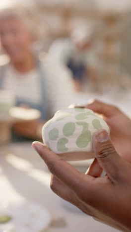hands of african american female potter holding clay in pottery studio, slow motion
