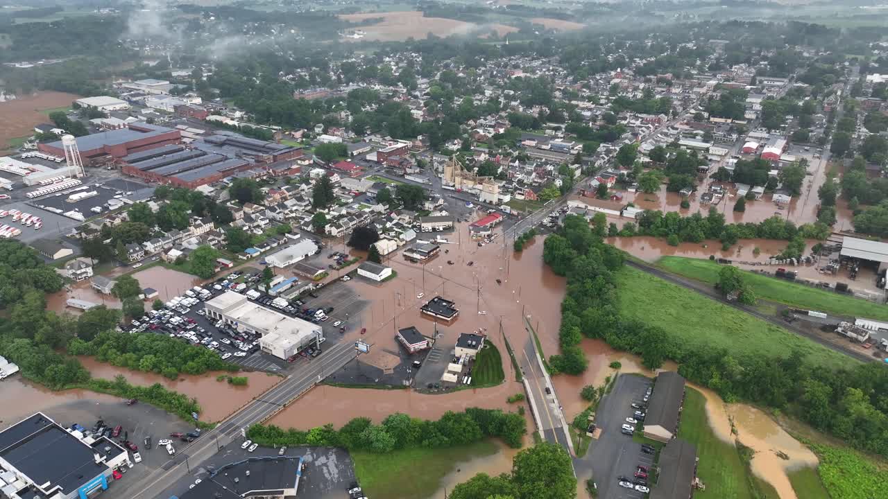 Città allagata in America dopo forti piogge notturne. Vista aerea dall'alto. Fango e acqua sporchi che scorrono per le strade e i campi. Case ed edifici distrutti e danneggiati in periferia