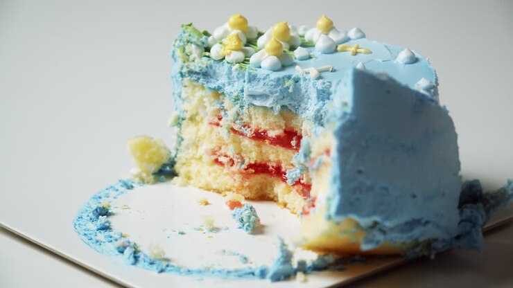 Piccola torta rotonda con glassa blu tagliata da una forchetta.